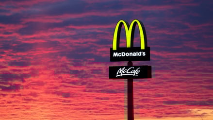 Der Abendhimmel leuchtet hinter einem McDonald’s-Logo.