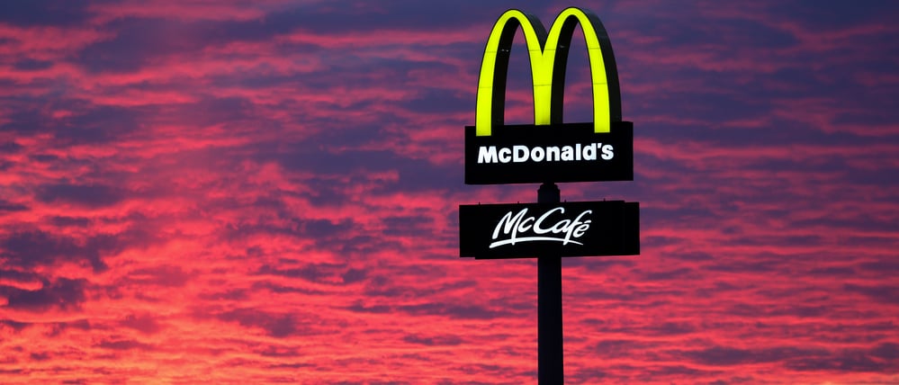 Der Abendhimmel leuchtet hinter einem McDonald’s-Logo.