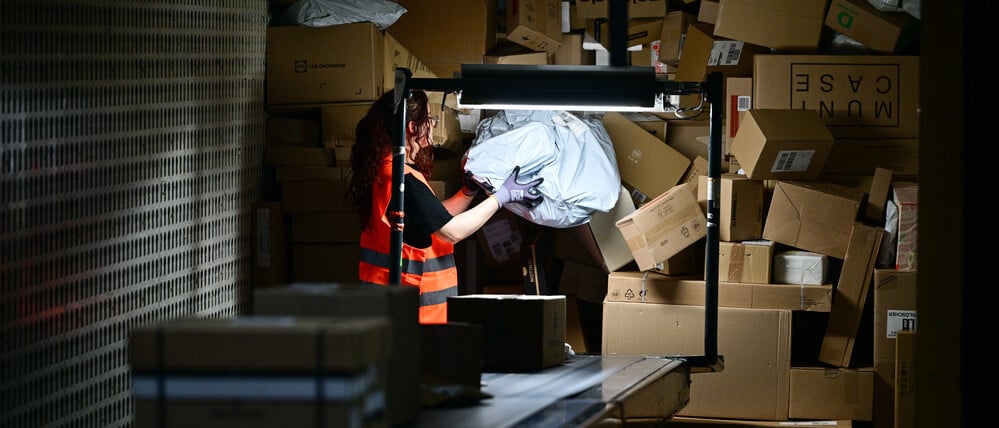 Eine Arbeiterin verlädt in der DHL-Zustellbasis Charlottenburg Pakete. 