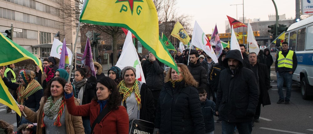 24.03.2018, Berlin: Teilnehmer an einer Demonstration gegen den türkischen Militäreinsatz in der syrischen Stadt Afrin, die überwiegend von Kurden bewohnt wird, gehen auf der Wilhelmstraße. Foto: Paul Zinken/dpa +++ dpa-Bildfunk +++