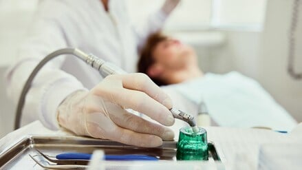 Ein Zahnarzt schaut sich die Zähne seiner Patienten an.