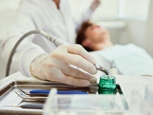 Ein Zahnarzt schaut sich die Zähne seiner Patienten an.