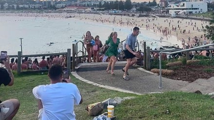 Screenshot aus einem Video, das fliehende Menschen am Bondi Beach zeigt.