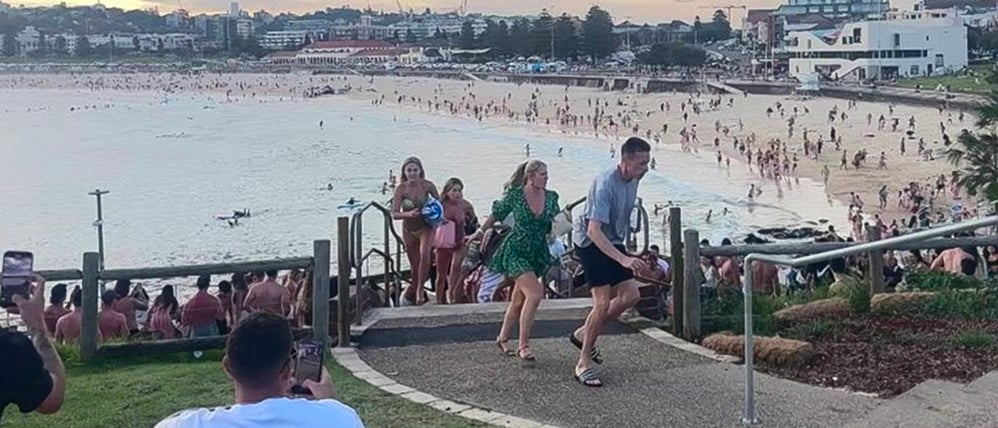 Screenshot aus einem Video, das fliehende Menschen am Bondi Beach zeigt.
