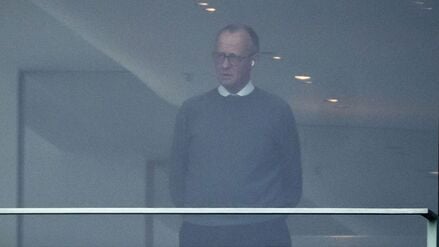 Bundeskanzler Friedrich Merz steht telefonierend in seinem Büro im Kanzleramt.