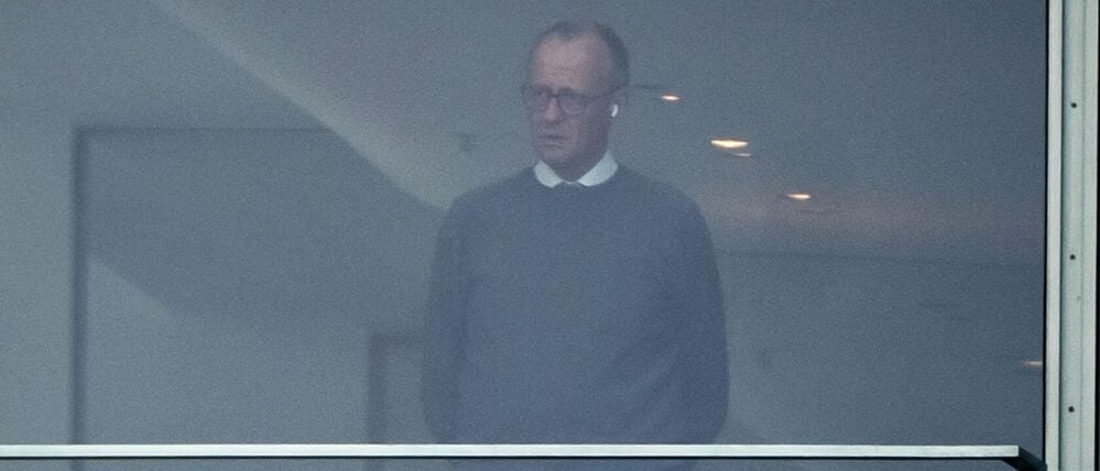 Bundeskanzler Friedrich Merz steht telefonierend in seinem Büro im Kanzleramt.