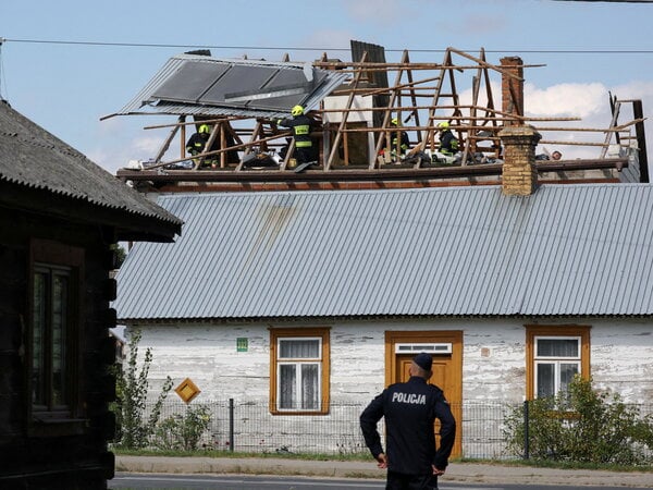 A police officer stands below as firefighters work on the destroyed roof of a house, after Russian drones violated Polish airspace during an attack on Ukraine, with some being shot down by Poland with the backing from its NATO allies, in Wyryki-Wola, Lublin Voivodeship, Poland, September 10, 2025. REUTERS/Kacper Pempel     REFILE - CORRECTING LOCATION FROM "WYRYKI" TO "WYRYKI-WOLA" .
Drones