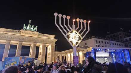Menschen haben sich am Sonntagabend für ein Solidaritätsgebet bei der Chanukka-Kerze am Brandenburger Tor versammelt.