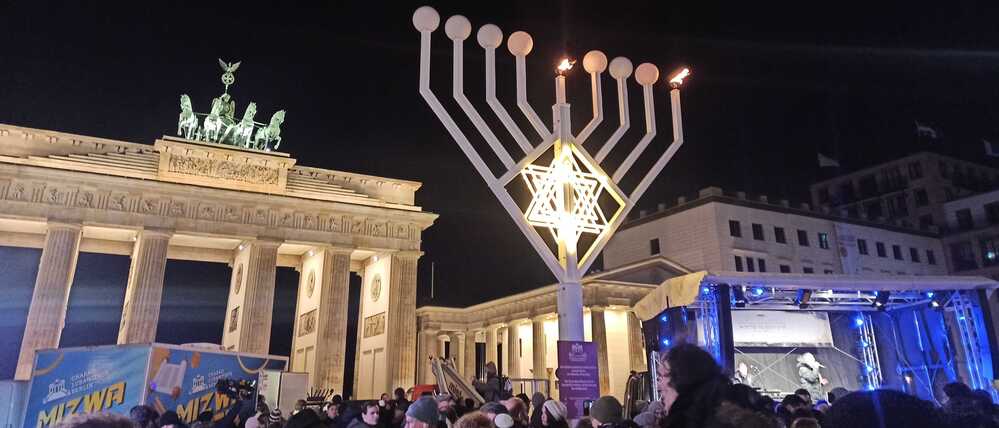 Menschen haben sich am Sonntagabend für ein Solidaritätsgebet bei der Chanukka-Kerze am Brandenburger Tor versammelt.
