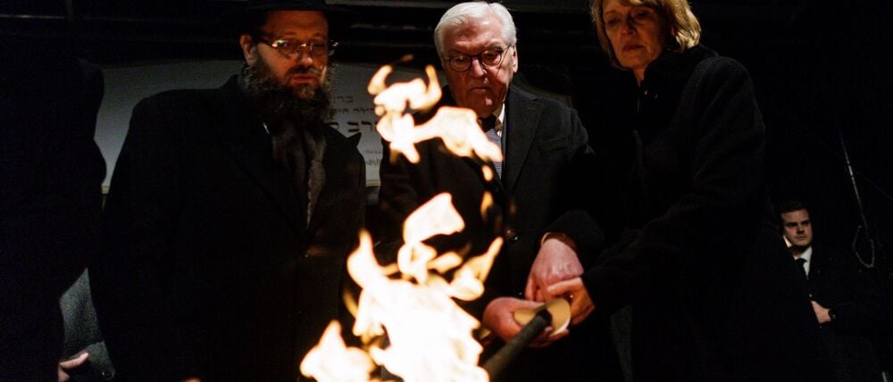 Stunden nach dem brutalen Anschlag in Sydney zündeten Rabbiner Yehuda Teichtal (l), Bundespräsident Frank-Walter Steinmeier und seine Frau Elke Büdenbender gemeinsam eine Fackel für die erste Kerze des Chanukka-Leuchters vor dem Brandenburg Tor an.
