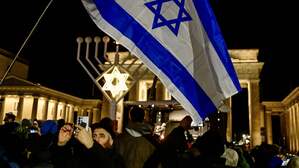Menschen haben sich am Sonntagabend für ein Solidaritätsgebet bei der Chanukka-Kerze am Brandenburger Tor versammelt.