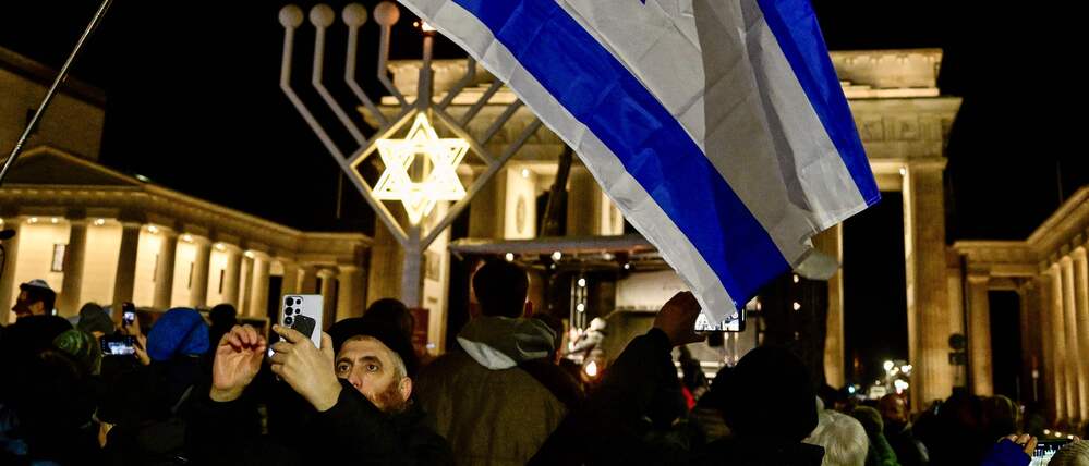 Menschen haben sich am Sonntagabend für ein Solidaritätsgebet bei der Chanukka-Kerze am Brandenburger Tor versammelt.