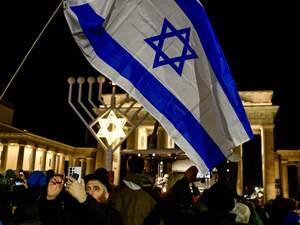 Menschen haben sich am Sonntagabend für ein Solidaritätsgebet bei der Chanukka-Kerze am Brandenburger Tor versammelt.