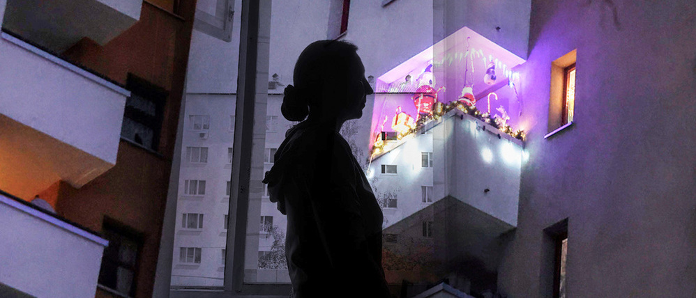 Die Illustration zeigt den Umriss einer Frau vor einer Wohnungsfassade. Sollten Normalverdiener eine Abgabe bezahlen, wenn sie in einer Sozialwohnung leben wollen?