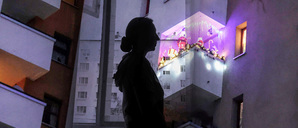 Die Illustration zeigt den Umriss einer Frau vor einer Wohnungsfassade. Sollten Normalverdiener eine Abgabe bezahlen, wenn sie in einer Sozialwohnung leben wollen?