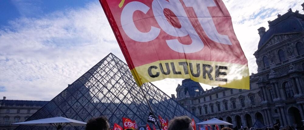 Angestellte zeigen eine Flagge der Gewerkschaft CGT vor dem Louvre, nachdem sie für einen Streik gestimmt haben.