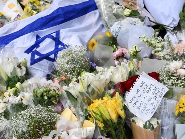An Israeli flag is placed among flower tributes near Bondi Pavilion following a shooting incident on a Jewish holiday celebration at Bondi Beach in Sydney, Australia, December 15, 2025. REUTERS/Flavio Brancaleone