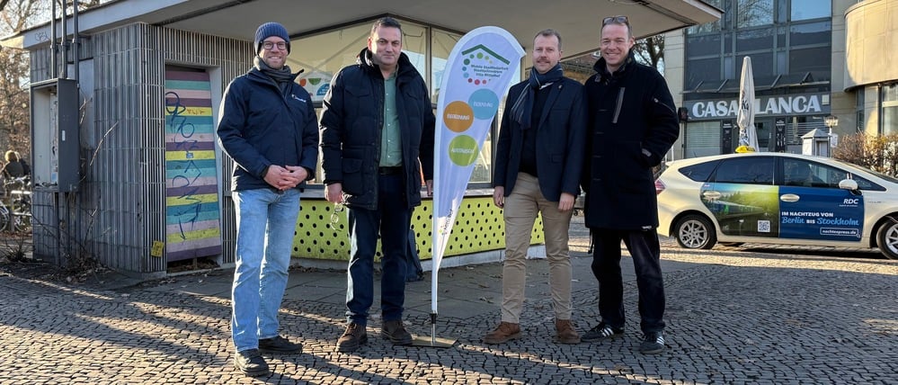 Soft-Opening des seit einem Jahr leer stehenden Kiosks auf der Dorfaue Zehlendorf am 15. Dezember 2025. Olaf Löschke (ganz links) und Markus Schönbauer (ganz rechts; beide vom Mittelhof), Umwelt- und Verkehrsstadtrat Urban Aykal (Grüne, mitte links) und Stadtentwicklungsstadtrat Patrick Steinhoff (CDU).