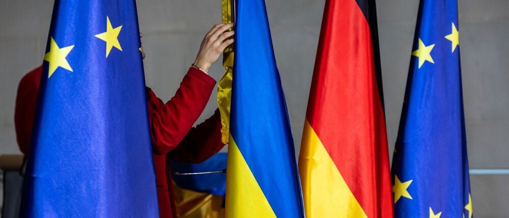 dpatopbilder - 15.12.2025, Berlin: Die Flaggen von Europa, der Ukraine und Deutschland werden zu der Pressekonferenz von Bundeskanzler Merz (CDU) und Selenskyj, Präsident der Ukraine im Kanzleramt aufgebaut. In Berlin finden Beratungen zu einem möglichen Frieden in der Ukraine statt. Foto: Michael Kappeler/dpa +++ dpa-Bildfunk +++