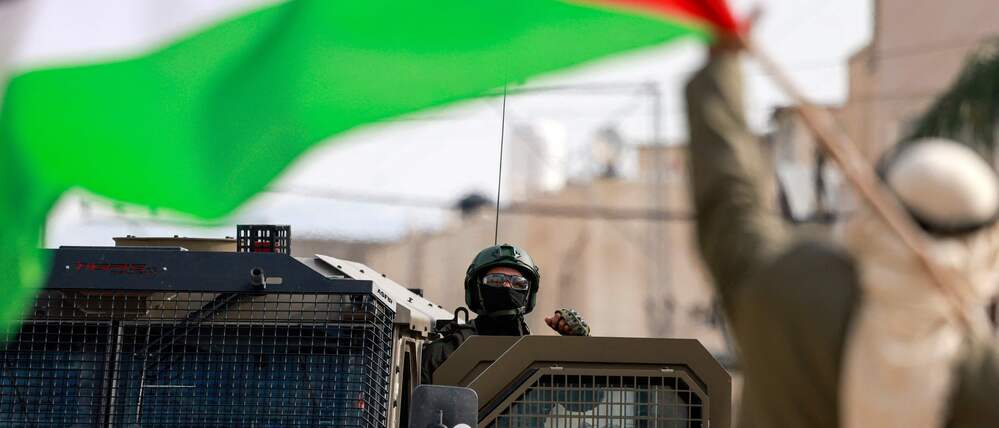 Ein Mann schwenkt die palästinensische Flagge vor einem israelischen Soldaten im Nur Shams Lager im Westjordanland (Symbolbild).