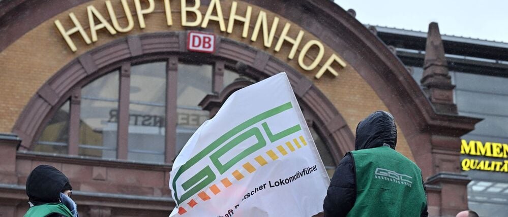 Vorerst ein Archivbild: Mitglieder der GDL stehen mit Fahne und Transparent vor dem Erfurter Hauptbahnhof.