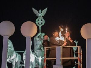 Rabbiner Yehuda Teichtal (M.) und Kalman Meir Ber (r.), Oberrabiner des Staates Israel, zünden mit Fackeln die erste Kerze des Chanukka-Leuchters auf dem Pariser Platz vor dem Brandenburger Tor anlässlich der beginnenden Chanukka-Feiertage an.