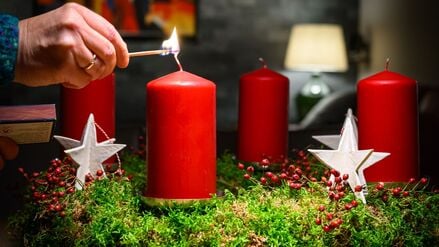 Die Kerze eines Adventskranzes wird angezündet (Symbolfoto).