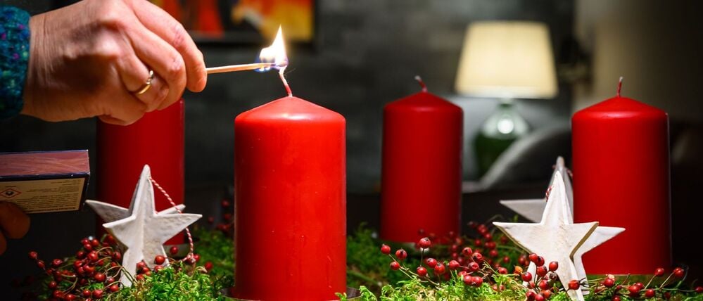 Die Kerze eines Adventskranzes wird angezündet (Symbolfoto).