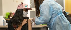 24.05.2021, USA, San Pedro: High-School-Neuling Jeff Eseroma, 14, wird in einer schulbasierten Corona-Impfklinik für Schüler ab 12 Jahren in San Pedro, Kalifornien, geimpft. Die Schulen setzen auf Maskottchen, Preise und Wettbewerbe, um Jugendliche ab 12 Jahren dazu zu bewegen, sich vor den Sommerferien gegen das Coronavirus impfen zu lassen. Foto: Damian Dovarganes/AP/dpa +++ dpa-Bildfunk +++