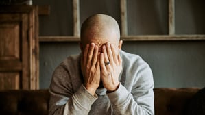 Ein offenbar erschütterter Mann hält die Hände vor sein Gesicht (Symbolbild).