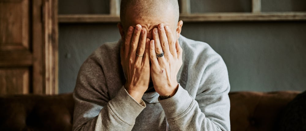 Ein offenbar erschütterter Mann hält die Hände vor sein Gesicht (Symbolbild).