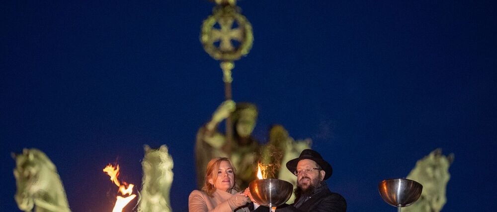 Bundestagspräsidentin Julia Klöckner und Rabbiner Yehudi Teichtal entzünden ein Licht.