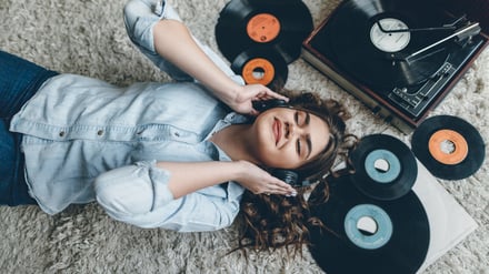 Young retro woman listening music on floor