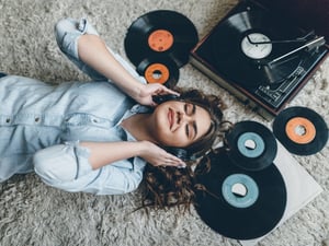Young retro woman listening music on floor