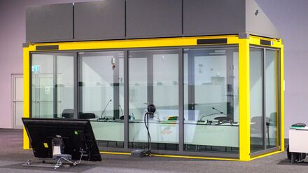 Blick auf den leeren Glaskasten im Gerichtssaal des temporären Gerichtsgebäudes vom Landgericht Magdeburg, in dem normalerweise der Todesfahrer vom Magdeburger Weihnachtsmarkt sitzt.