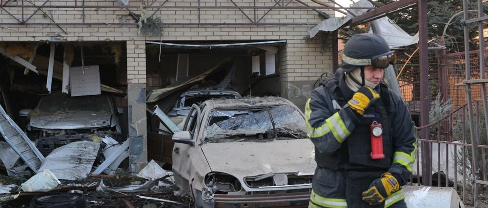 Ein Rettungsarbeiter geht vor einem Wohnhaus, das nach einem russischen Angriff auf Saporischschja in der Ukraine beschädigt wurde