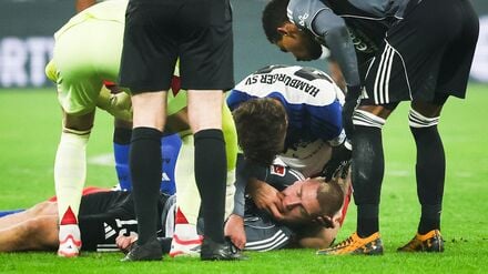 HSV-Verteidiger Luka Vuskovic hilft dem am Boden liegenden Eintracht-Profi Rasmus Kristensen. 