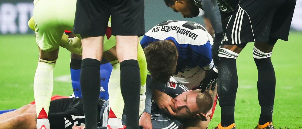 HSV-Verteidiger Luka Vuskovic hilft dem am Boden liegenden Eintracht-Profi Rasmus Kristensen. 