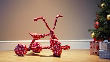 Ein als Geschenk verpacktes Dreirad.