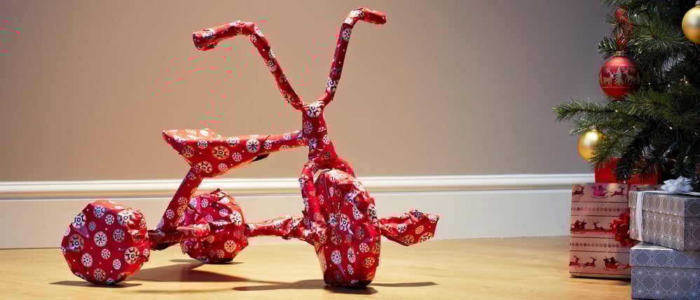 Ein als Geschenk verpacktes Dreirad.