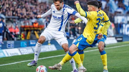 Die Braunschweiger Johan Gomez (verdeckt, Eintracht Braunschweig) und Robin Heußer bedrängen den Schalker Kenan Karaman (l).