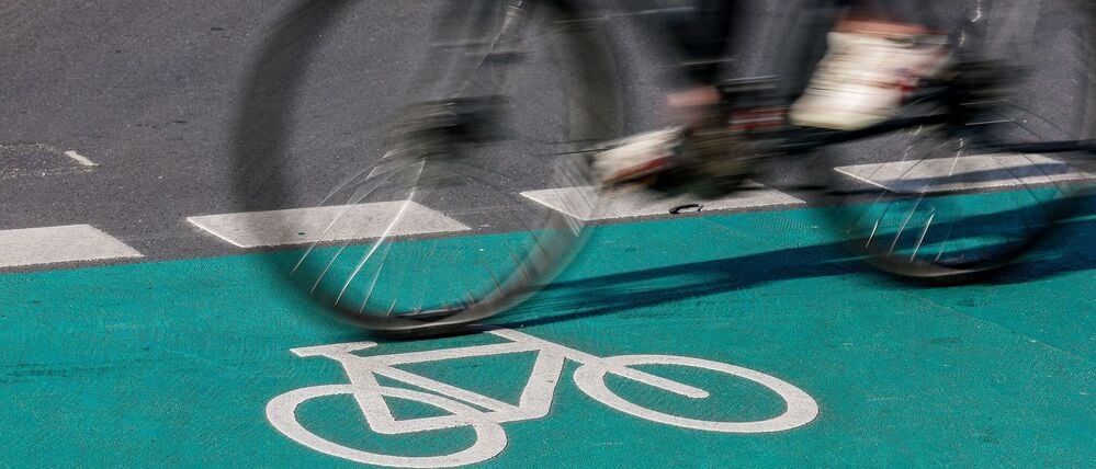 Eine Radfahrerin fährt über einen grün eingefärbten Radweg.