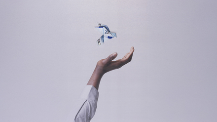 Symbolbild für schwindenden Wohlstand: Ein 20-Euro-Schein, der zu einem Vogel gefaltet ist, fliegt aus einer Hand davon.