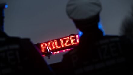 Zwei Polizisten stehen vor einem Schriftzug „Polizei“ (Symbolbild)