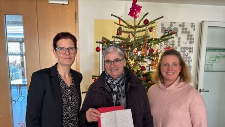 Die Vorständin des Sozialdienstes katholischer Frauen der Diözese Rottenburg-Stuttgart, Svenja Gruß (l), steht neben Schwester Nicola Maria, und Daniela Kob (r), Einrichtungsleiterin Paulusstift. Schwester Nicola Maria hält den Spendenbrief eines Obdachlosen aus Stuttgart in der Hand, der 200 Euro an Mütter in Not gespendet hat. 