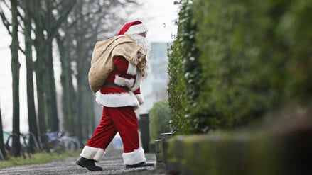 Ein als Weihnachtsmann verkleideter Mann ist am Heiligabend auf dem Weg zu einer Familie.