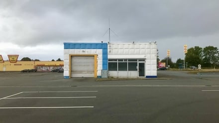 Ein leerer Parkplatz eines Supermarktes mit einer geschlossenen Autowerkstatt und trübem Himmel, aufgenommen in der Stadt Rendsburg in Schleswig-Holstein während der Corona-Pandemie im Oktober 2021.
