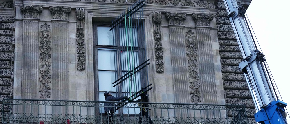 Arbeiter montieren am 23. Dezember 2025 in Paris, wenige Wochen nachdem Diebe mit einem Möbelaufzug in den Louvre eingebrochen waren, eiserne Fenstergitter an den Fenstern.