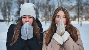 Zwei Frauen bibbern in der Kälte. 