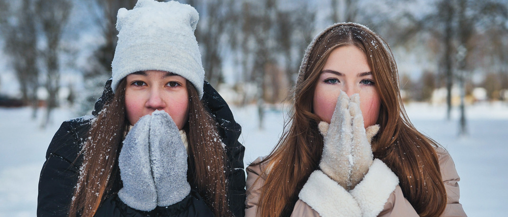 Zwei Frauen bibbern in der Kälte. 